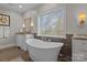 Elegant bathroom featuring a standalone tub, granite countertops, and stylish fixtures at 110 Lynbrook Dr, Davidson, NC 28036