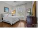 Bright bedroom with a white bed, hardwood floors, and a large window with a backyard view at 110 Lynbrook Dr, Davidson, NC 28036