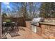 Outdoor kitchen with a brick counter and stainless steel grill, plus an adjacent dining area at 110 Lynbrook Dr, Davidson, NC 28036