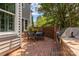 Charming outdoor brick patio with a dining table, grill, and well-maintained landscaping at 110 Lynbrook Dr, Davidson, NC 28036