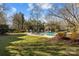 An in-ground pool is surrounded by manicured lawns and lounge chairs, with mature trees providing shade at 110 Lynbrook Dr, Davidson, NC 28036