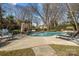 A luxurious in-ground pool is surrounded by a stone patio, lounge chairs, and an outdoor fireplace at 110 Lynbrook Dr, Davidson, NC 28036