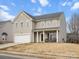 Two-story home with neutral siding, well-manicured lawn, covered porch, and attached two-car garage at 1115 Ross Brook Trce, York, SC 29745