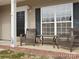 Inviting front porch with outdoor seating, black front door, and large windows at 1115 Ross Brook Trce, York, SC 29745