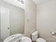 Simple half bathroom featuring tile floors, toilet, sink, mirror and lighting at 12218 Stewarts Crossing Dr, Charlotte, NC 28215