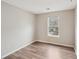 Bright bedroom featuring modern laminate flooring and a window offering natural light at 12218 Stewarts Crossing Dr, Charlotte, NC 28215