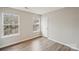 Bedroom featuring two bright windows and sleek, modern wood-look flooring at 12218 Stewarts Crossing Dr, Charlotte, NC 28215