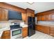 Kitchen with wood cabinets, tile countertops, and stainless steel appliances at 1308 Gum Branch Rd, Charlotte, NC 28214