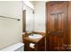 Small bathroom with single sink and wood cabinets at 1318 Gum Branch Rd, Charlotte, NC 28214