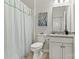 Bright bathroom showcasing a toilet, vanity with storage, and shower with a patterned curtain at 132 Picasso Trl, Mount Holly, NC 28120