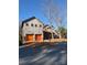 A stunning two-story home with a barn-like structure and vibrant orange garage doors at 132 Picasso Trl, Mount Holly, NC 28120