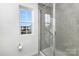 Modern bathroom features a glass-enclosed shower and a window with a view of the neighborhood at 1433 Harleston St, Indian Trail, NC 28079