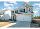 Inviting two-story home with a spacious two-car garage and a manicured lawn at 1433 Harleston St, Indian Trail, NC 28079