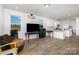 Open living space with wood-look floors, two windows, and a view of the kitchen with an island at 1433 Harleston St, Indian Trail, NC 28079