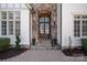 Elegant home entrance with double doors, stone accents, and a brick walkway at 20517 Queensdale Dr, Cornelius, NC 28031