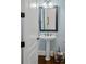 Stylish powder room with pedestal sink and dark framed mirror at 20517 Queensdale Dr, Cornelius, NC 28031