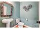 Charming powder room with a pedestal sink, framed mirror, and modern wall decor at 2222 Bluebell Way, Fort Mill, SC 29708