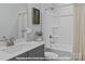 A full bathroom featuring a shower over tub, gray cabinets, and brushed silver hardware at 272 Gilead Rd, Huntersville, NC 28078