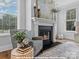 Close-up of the fireplace, features comfortable armchair, decor, and natural light at 272 Gilead Rd, Huntersville, NC 28078