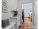 Mudroom offers white bench with cabinet storage and view into kitchen, featuring stainless steel appliances at 272 Gilead Rd, Huntersville, NC 28078