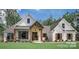 White farmhouse exterior with brown accents and a landscaped lawn at 295 Tradition Dr, Mount Gilead, NC 27306