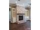 Stone fireplace with built-in shelving and hardwood floors at 295 Tradition Dr, Mount Gilead, NC 27306