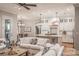 Open-concept living space with white sofa, hardwood floors, and adjacent to a modern kitchen at 295 Tradition Dr, Mount Gilead, NC 27306