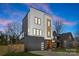 Modern two-story home featuring a gray garage door, wood accents, and neutral colors at 3132 Carol Ave, Charlotte, NC 28208