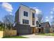 Modern home has a gray garage, white siding, a wooden facade and dark trim windows at 3132 Carol Ave, Charlotte, NC 28208