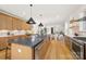 Spacious kitchen featuring wooden cabinets, a gray island, and an open layout to the dining area at 3132 Carol Ave, Charlotte, NC 28208