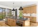 Kitchen island with modern light fixtures, stainless steel appliances, and a view of the backyard at 3132 Carol Ave, Charlotte, NC 28208