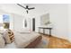 Bright main bedroom featuring hardwood floors, a ceiling fan, and stylish decor at 3132 Carol Ave, Charlotte, NC 28208