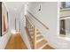Hallway stairs include a wooden handrail and black metal spindles plus hardwood floors at 3132 Carol Ave, Charlotte, NC 28208