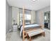 Bright bedroom featuring four-poster bed with stylish bedding, decorative pillows, bench, and neutral gray walls at 3134 Sterling Ct, Fort Mill, SC 29707