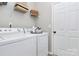 Well-lit laundry room featuring a white washer and dryer with convenient overhead shelving for storage at 3134 Sterling Ct, Fort Mill, SC 29707