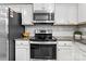 Close-up of a kitchen featuring modern appliances and white cabinets with granite countertops at 5025 Macvittie Ln, Charlotte, NC 28214