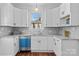 Bright kitchen with white cabinets, blue dishwasher, granite countertops, and a window overlooking the backyard at 506 S Church St, Salisbury, NC 28144