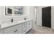 Bathroom featuring double vanity with white countertop and dark faucet hardware, plus wood look tile flooring at 529 Veloce Trl, Fort Mill, SC 29715