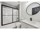 Modern bathroom featuring a shower with black trim, round mirror, and white vanity at 529 Veloce Trl, Fort Mill, SC 29715