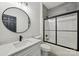 Bathroom featuring modern vanity, round mirror, toilet, and tiled shower with black trim at 529 Veloce Trl, Fort Mill, SC 29715