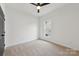 Bright bedroom with neutral carpet, white walls, ceiling fan, and natural light at 529 Veloce Trl, Fort Mill, SC 29715