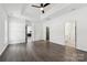 Bright bedroom featuring hardwood floors, tray ceiling, ceiling fan and two entryways for convenience at 529 Veloce Trl, Fort Mill, SC 29715