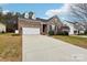 Charming brick home featuring a two-car garage, dormer windows, and manicured landscaping at 529 Veloce Trl, Fort Mill, SC 29715