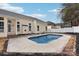 Backyard view featuring a private pool and light yellow home exterior with white trim, surrounded by concrete and mulch at 529 Veloce Trl, Fort Mill, SC 29715