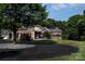 A paved driveway leads to a beautifully crafted stone and brick home nestled among lush trees and manicured landscaping at 5645 White Store Rd, Wingate, NC 28174