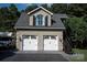 A two-car garage with an upper level apartment featuring a striking arched window and stairway at 5645 White Store Rd, Wingate, NC 28174