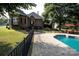 A stunning pool area features a sleek black fence, pool-side seating, and glimpses of the home's exterior at 5645 White Store Rd, Wingate, NC 28174