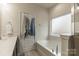 Bright bathroom featuring a soaking tub, tiled floors, and a separate shower at 5826 Castlecove Rd, Charlotte, NC 28273