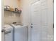 Laundry room with washer, dryer, and storage shelves at 5826 Castlecove Rd, Charlotte, NC 28273