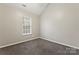 Well-lit bedroom featuring a window and neutral-toned carpet at 5851 Brookfield Pointe Dr, Charlotte, NC 28216